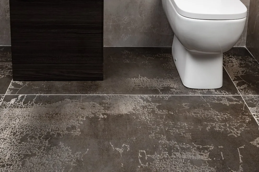 A person collapsed on the bathroom floor, overwhelmed by sudden abdominal pain