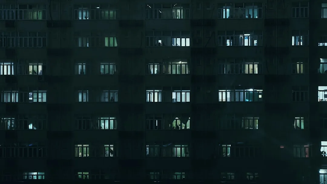 hopeful woman looking out hospital window moody natural lighting candid