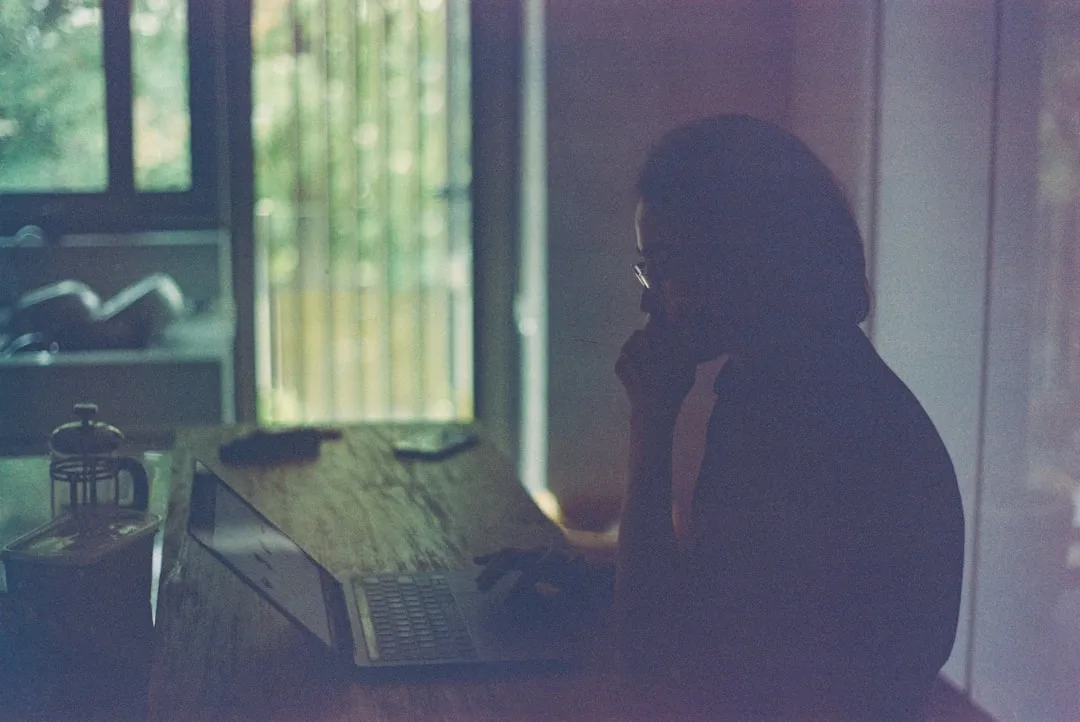 grieving widow looking at laptop candid natural lighting moody