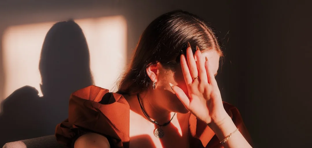stressed woman head in hands natural lighting moody emotional tension
